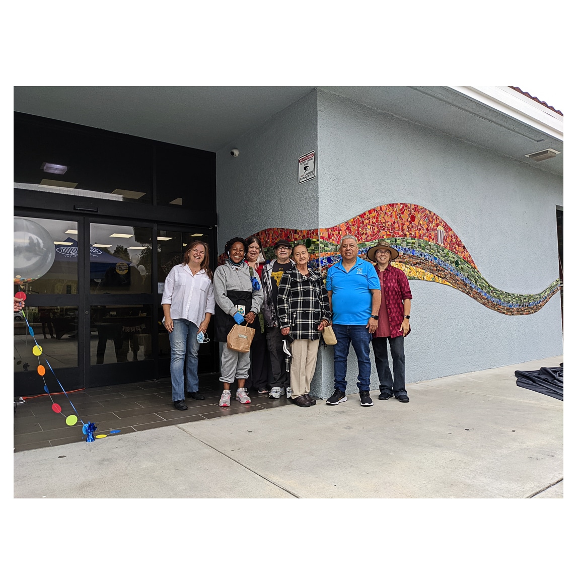 Los Angeles mosaic arts nonprofit Piece by Piece in front of mural ig